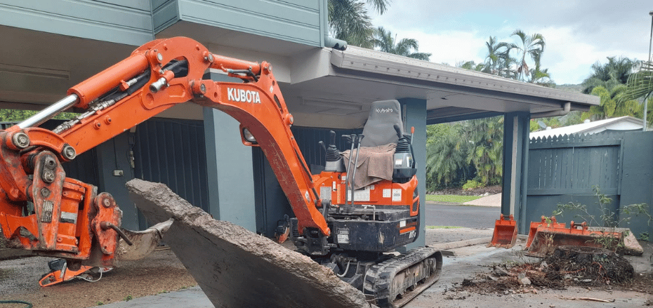 Earthworks ripping up concrete in a back yard in cairns