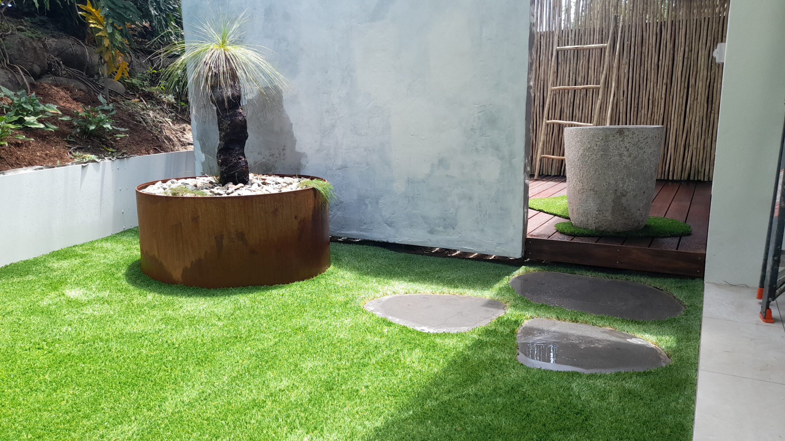 landscaping feature corner with artificial turf and stepping stones